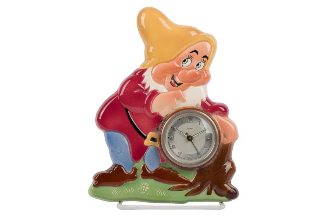 A 1950s "Snow White and the Seven Dwarfs" Happy Clock.: (Waechtersbach Works, 1950s) A ceramic clock inspired by Walt Disney's "Snow White and the Seven Dwarfs" featuring Happy, manufactured by Waechtersbach Works in Germany. The clock has not been tested 