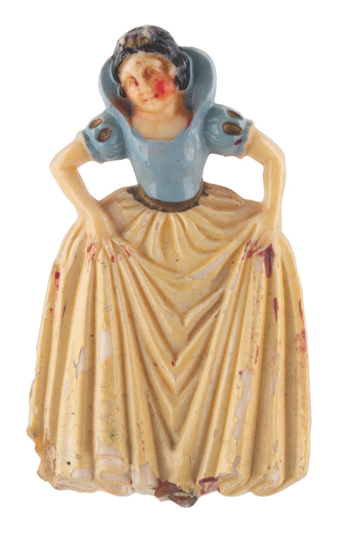 A Celluloid "Snow White" Brooch.: (Disney, 1930s-40s) A hand-painted celluloid Snow White brooch made in Czechoslovakia. Measuring 2" tall, the brooch is in good condition with light discoloration, soiling and spots of paint loss.