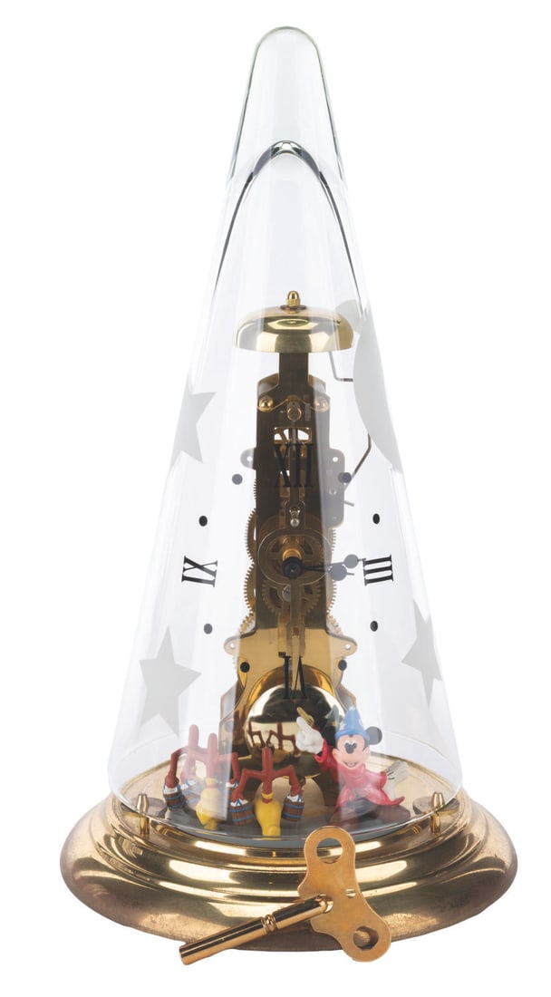 A Walt Disney Gallery "Fantasia" Pendulum Clock.: (The Walt Disney Gallery, 2000s) A rare Franz-Hermle mechanical pendulum clock featuring Sorcerer Mickey from Walt Disney's "Fantasia." The clock has a clear glass "hat" dome with stars and a moon, wi