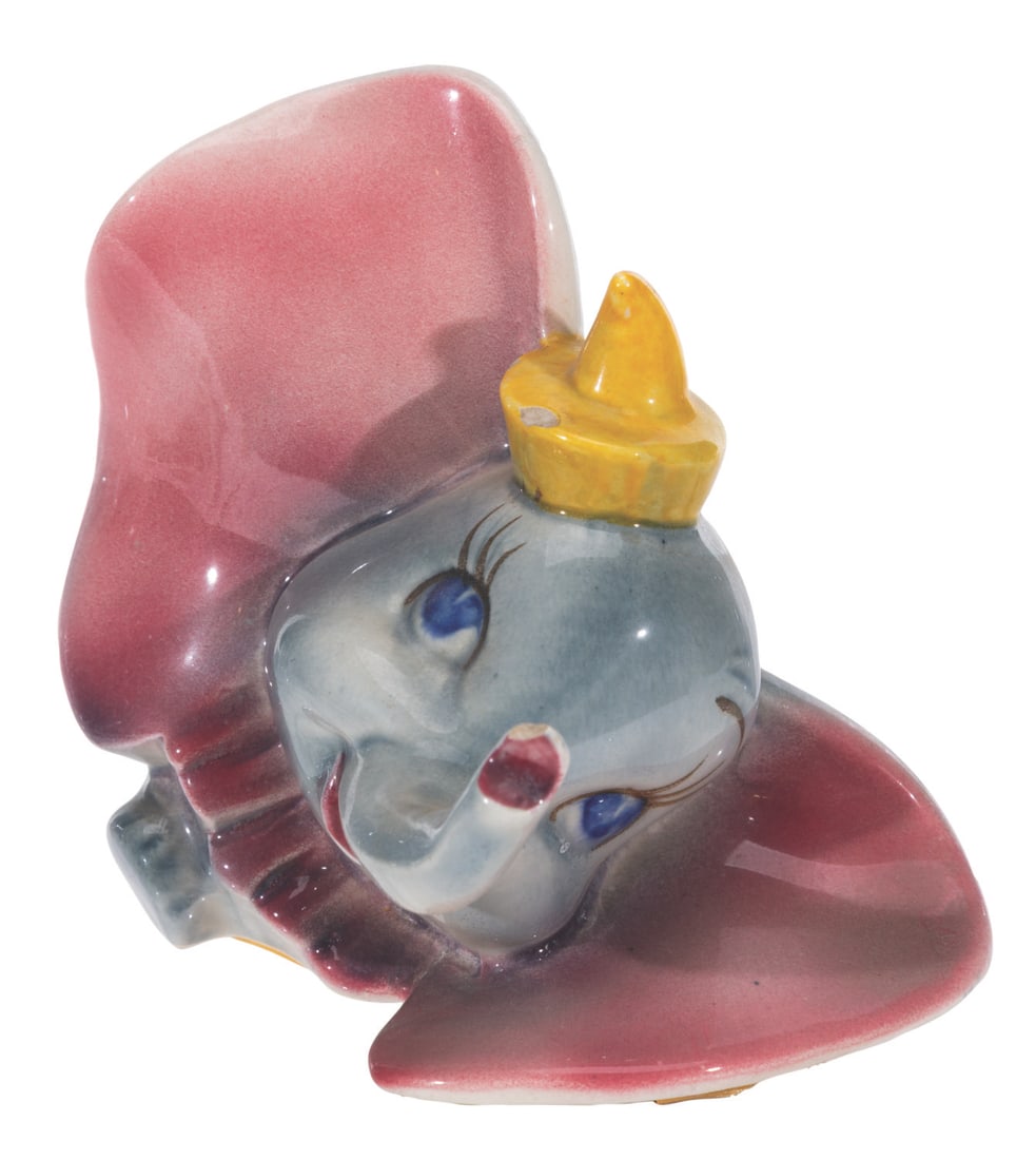 A "Dumbo" Figurine by Vernon Kilns.: (Vernon Kilns, 1941) A figurine of Dumbo manufactured by Vernon Kilns. Measuring 5.5" x 4" x 4.5" tall, the ceramic figurine is in good condition with spots of paint loss, wear, and chipping on the ha