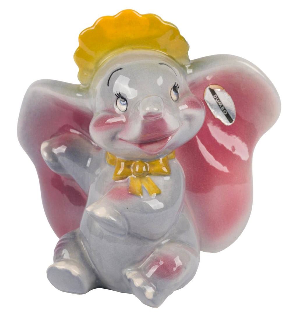A Dumbo Ceramic Figurine by Shaw Pottery.: (Shaw, 1940s-50s) A painted and glazed ceramic figurine of Dumbo manufactured by Evan K. Shaw Pottery. Measuring 5" x 3.75" and 5.25" tall, Dumbo is in very good condition with light crazing.