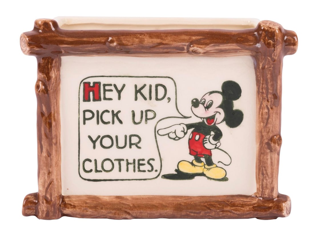 A Mickey Mouse Ceramic Planter by Evan K. Shaw Pottery.: (Shaw, 1950s) A Mickey Mouse ceramic planter that reads "Hey Kid, Pick Up Your Clothes." Measuring 2.25" x 6.5" and 5" tall, the planter is in very good condition with crazing to the back.