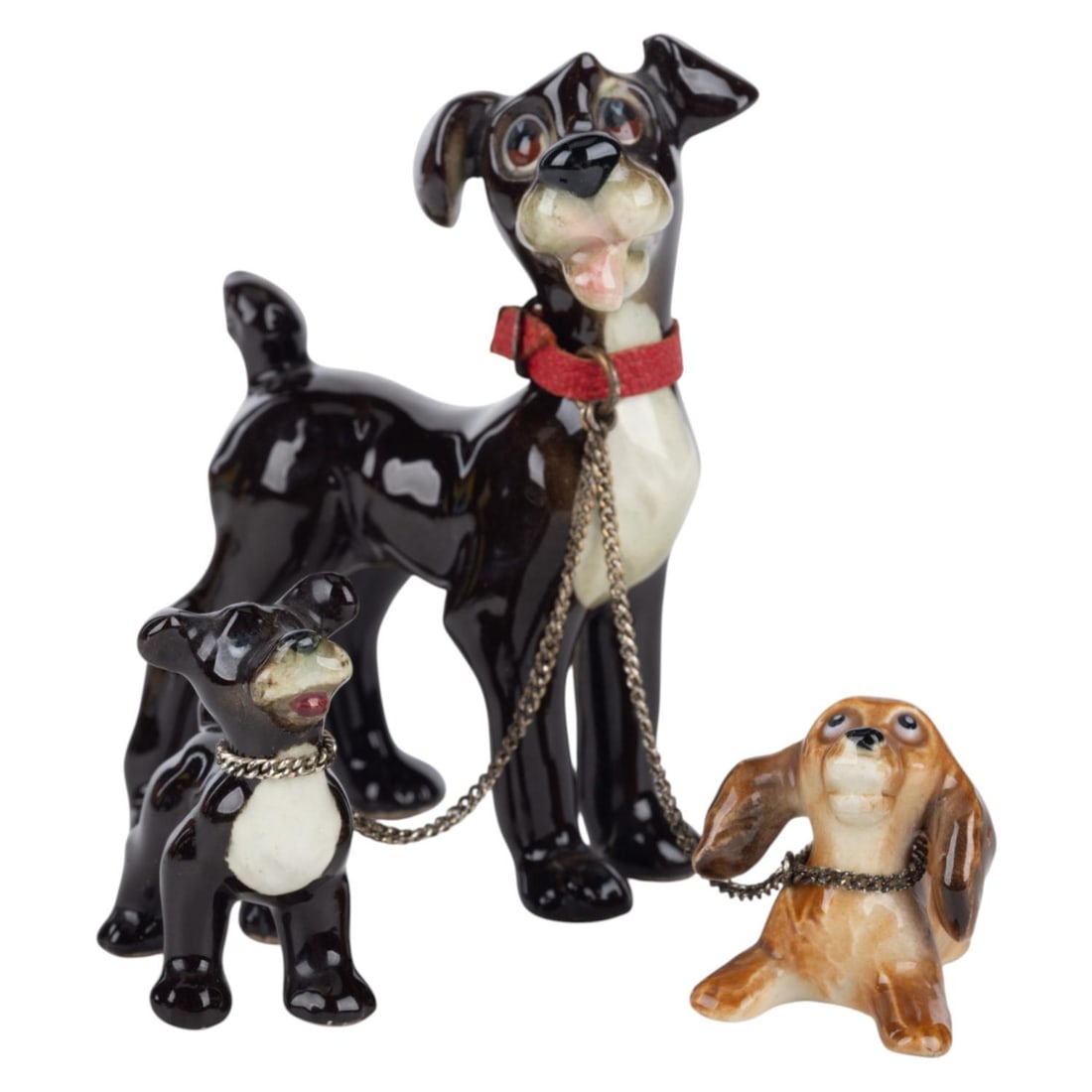A Tramp with Puppies Ceramic Figurine Set by Goebel.: (Goebel, 1950s) A set of three ceramic figurines from "Lady and the Tramp." Featuring Tramp with two puppies, the figurines were created by German Ceramists Goebel, best known for their Hummel