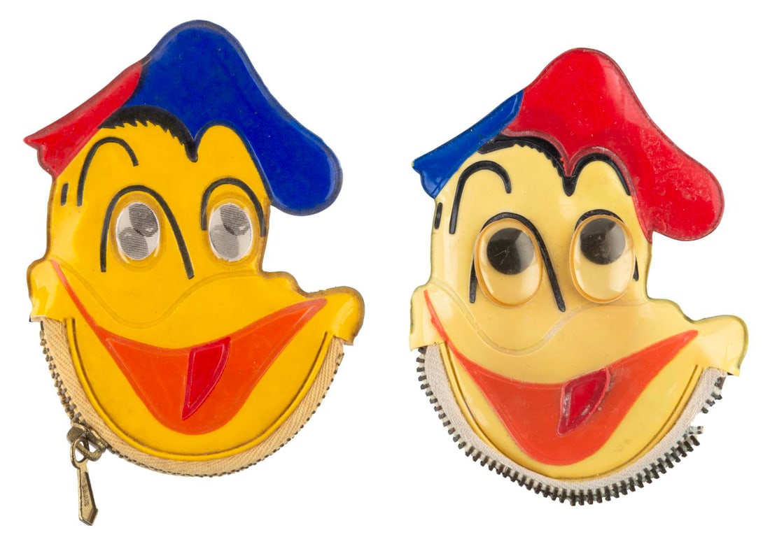 A Pair of Donald Duck Coin Purses.: (Disney, 1960s) A pair of unusual Walt Disney's Donald Duck vinyl coin purses, one with lenticular eyes and one with googly eyes. Measuring 3" x 4" each, the coin purses display in good condition with