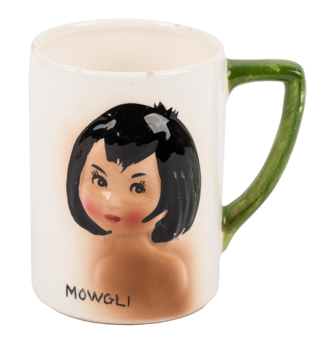 A 1960s "The Jungle Book" Mowgli Mug.: (Enesco, 1960s) A ceramic mug with a 3D relief of Mowgli from "The Jungle Book." Measuring 3.75" x 2.75" and 3.75" tall, the mug is in very good condition with crazing and small chips along the rim