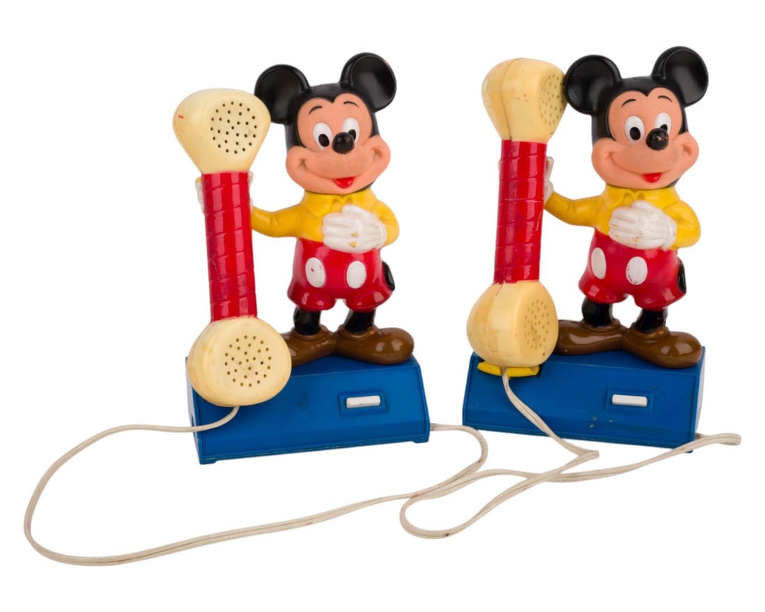 A 1970s Mickey Mouse Walkie Talkie Intercom Set.: (Disney, 1977) A figural Walkie Talkie Intercom set featuring Mickey Mouse holding out the receiver. The set requires four "C" batteries (not included) and a missing cord, so function has not been