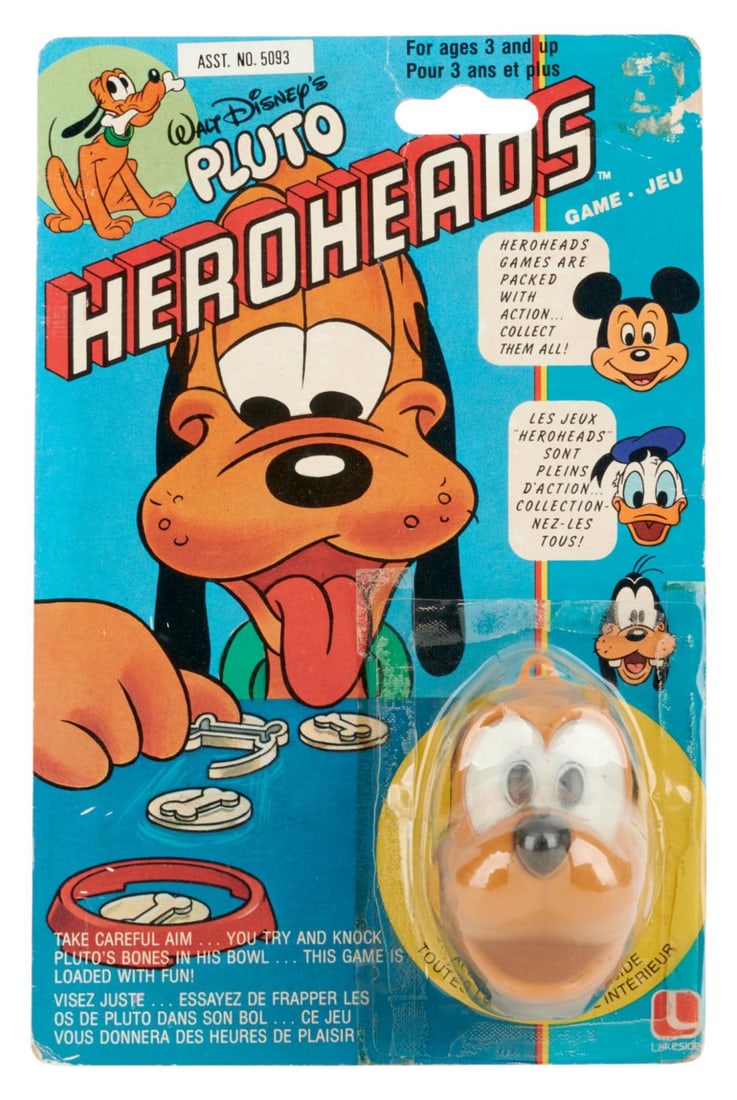 A Pluto Heroheads Game on the Original Card.: (Lakeside Games, 1981) A Walt Disney's Pluto Heroheads game featuring Mickey's canine companion. The game consists of a bowl, shooter, and 3 bone chip pieces inside a Pluto head container. Sealed to