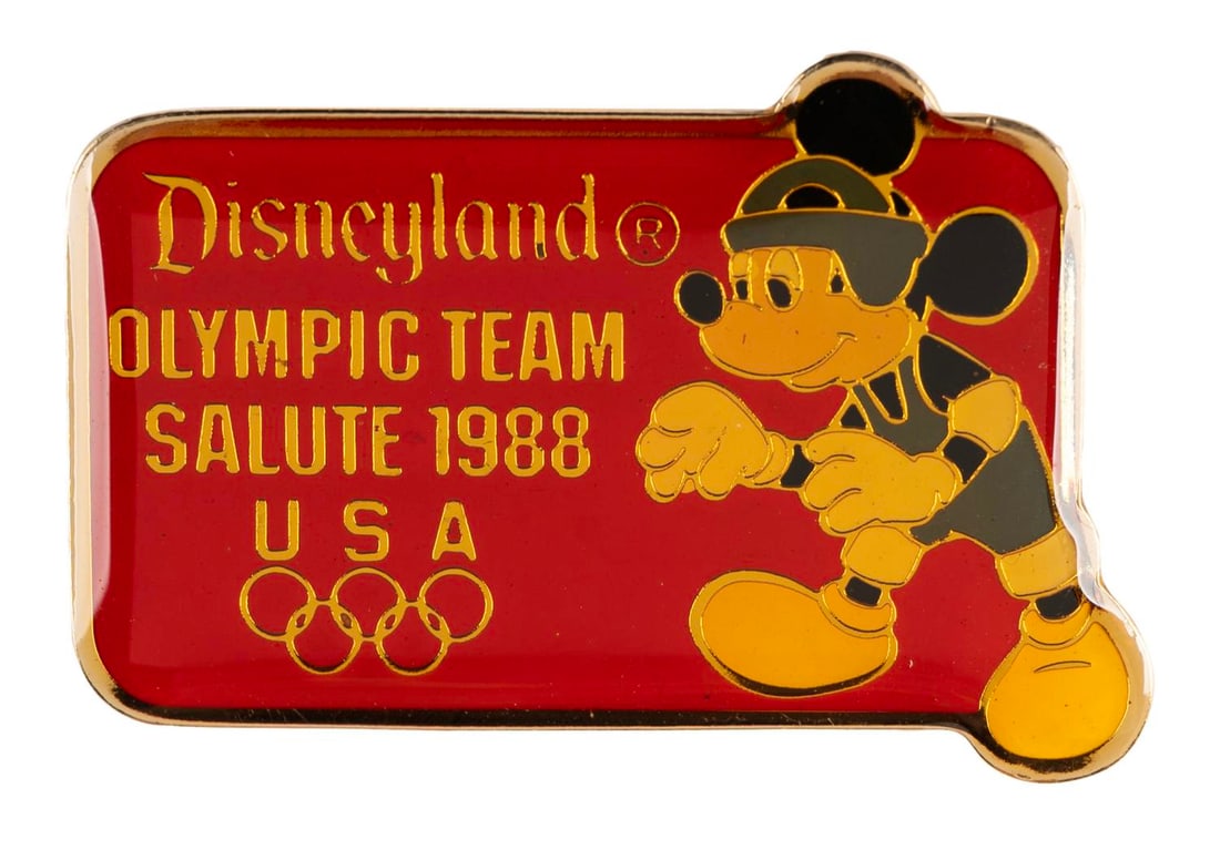 A Mickey Mouse Olympic Wrestling Pin.: (Disneyland, 1988) A Disneyland Olympic Team Salute 1988 pin featuring Mickey Mouse wrestling. Measuring 1.5" wide, the pin is in very good condition with color shift from age.