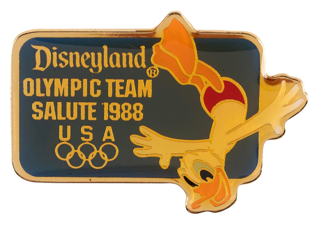 A Donald Duck Olympic Diving Pin.: (Disneyland, 1988) A Disneyland Olympic Team Salute 1988 pin, featuring Donald Duck diving. Measuring 1.25" wide, the pin is in very good condition with color shift from age.