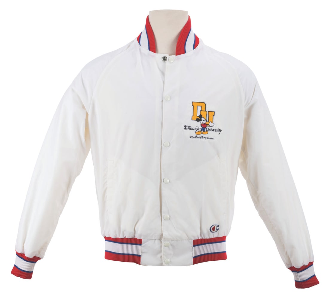A Disney University Jacket.: (Disney, 1990s) A Champion jacket featuring a Mickey Mouse Disney University patch embroidered on the left chest. Labeled a size Medium, the jacket is in very good condition with a minor stain and lig