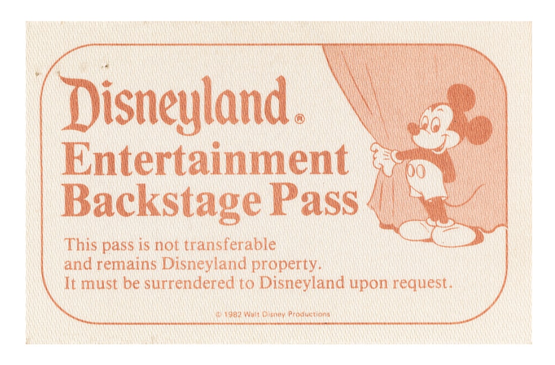 A Disneyland Entertainment Backstage Pass.: (Disneyland, 1982) An Entertainment Backstage Pass for Disneyland performers and entertainers. This pass features an image of Mickey holding open a curtain, and is printed on a textured fabric-like