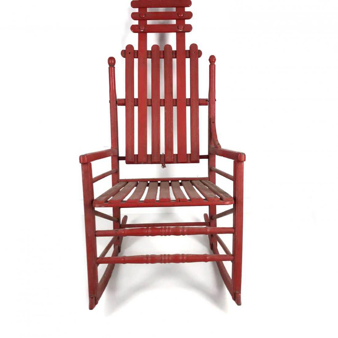 Antique Folk Art Red Painted Slat Wood Rocking Cha: Antique Folk Art Style Red Painted Slat Wood Rocking Chair Very unique and rare styling - one of a kind - with swinging back. Fantastic red paint.Measures: 19 inch width x 26 inch depth x 39 inch heig