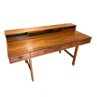 Jens Quistgaard of Dansk Peter Lovig Nielsen Desk: Iconic Danish modern teak desk by Jens Quistgaard of Dansk for Peter Lovig Nielsen. The desk offers a very practical hinged gallery to top that flips down to expand into a partners desk or extended wo