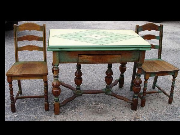 English-style pub table and two chairs: Manufactured by Lewisburg Chair Co. ca 1887-1915. One chair has repaired runner. Table has Jacobean legs, stretcher base, green paint, enamel top. Table top measures 25"w x 40" l, closed.