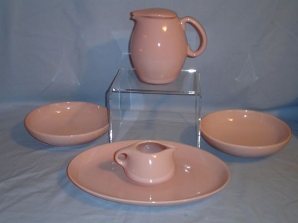 5 Pieces of Russel Wright Iroquois Pink Sherbert: 1 oval platter, measurements: 12 1/4", 2 round serving bowls, measurements: 8", 1 small pitcher with lid, measurements: 6 1/4" (h) and 1 creamer, measurements: 3" (h). Good condition, no chips or crac
