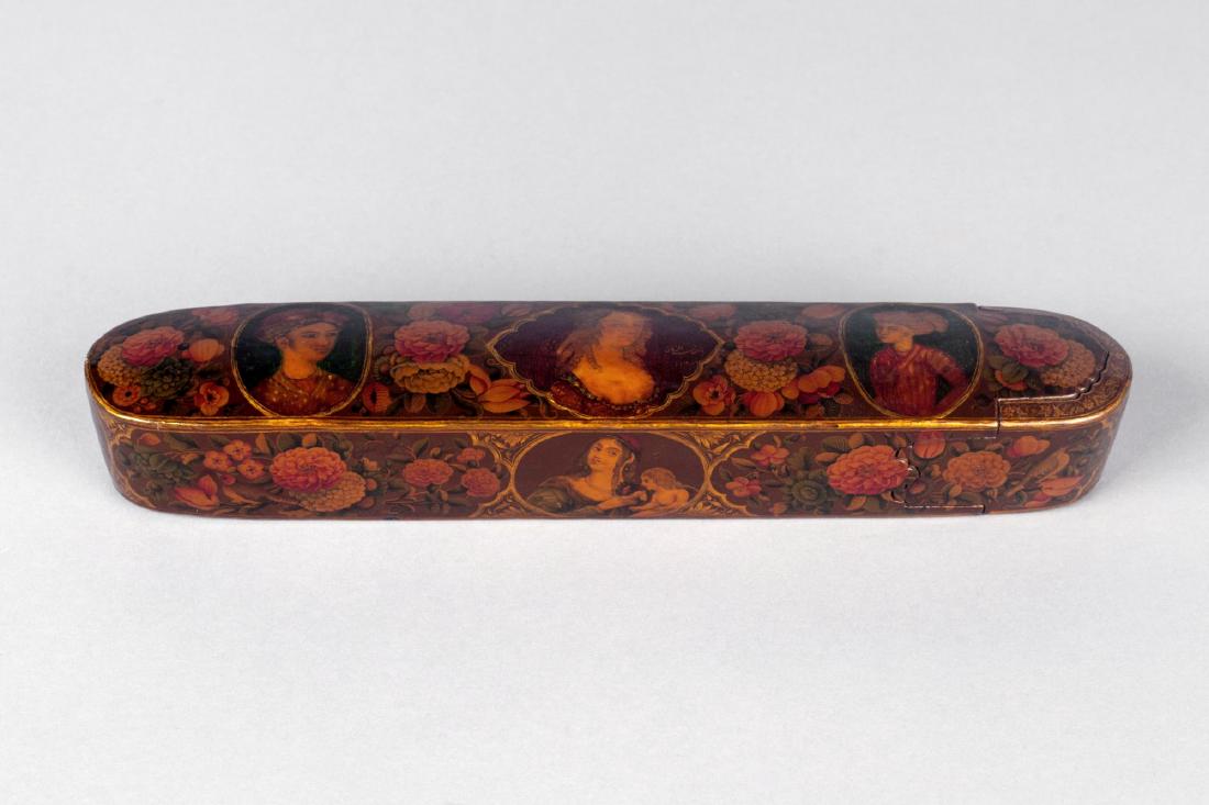 A polychrome lacquer papier mache qalamdan (pencase),: A polychrome lacquer papier mache qalamdan (pencase), signed by ..., Iran, 18th century, the painted decoration consisting of a European lady with ringlets set with a lobed medallion, two youths eithe