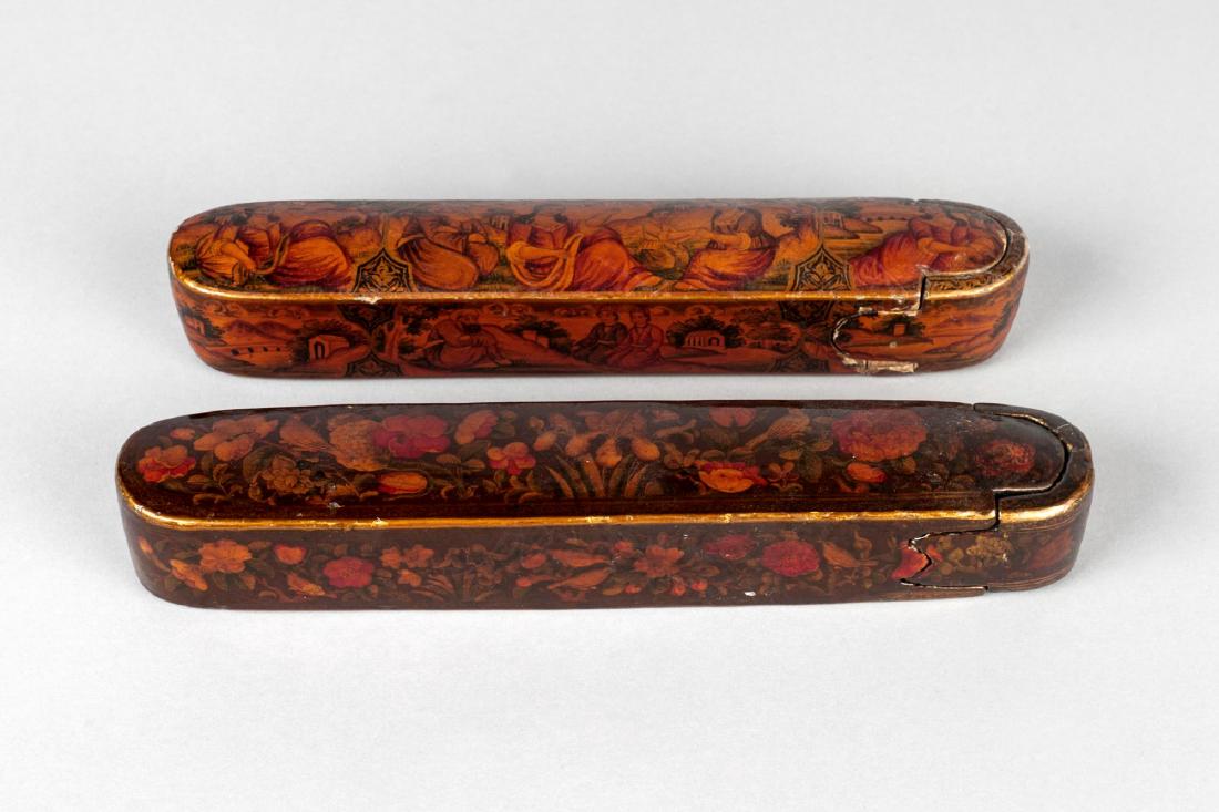 Two Qajar polychrome lacquer papier mache qalamdan: Two Qajar polychrome lacquer papier mache qalamdan (pencase), Iran, 19th century, the first decorated with painted Europeanized pastoral scenes, and the second with bul bul and roses, 22.5cm and 21.8c