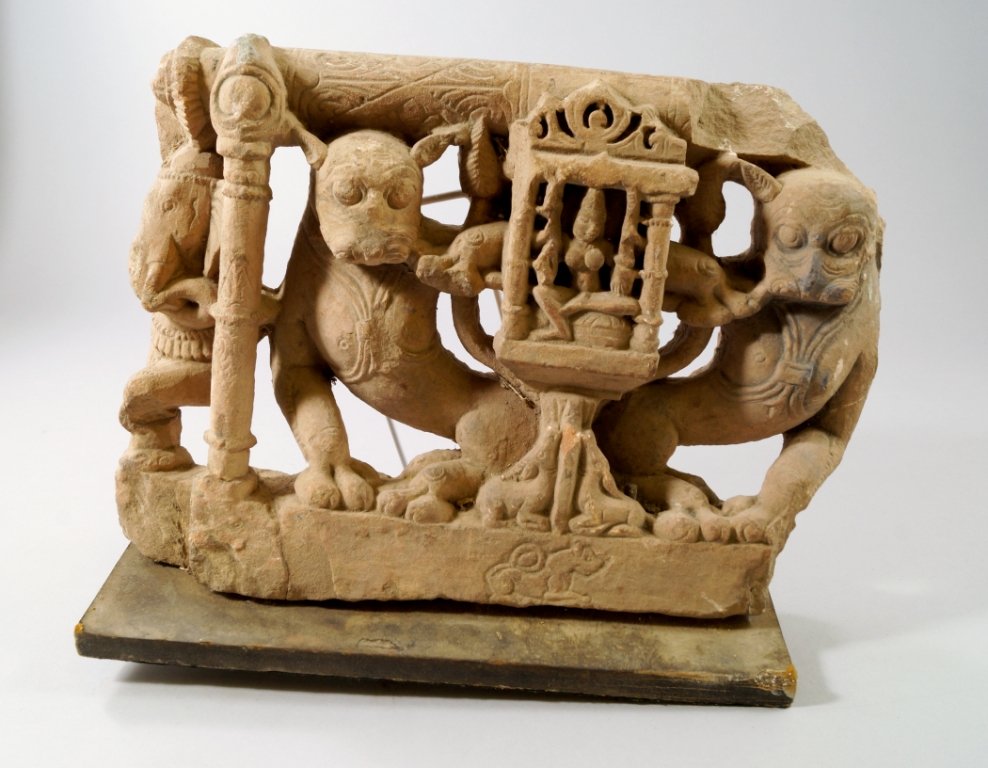 An Indian red stone architectural fragment of mythical: An Indian red stone architectural fragment of mythical animals, 11th/12th Century, possibly from Rajasthan, carved and pierced with two lions flanking a shrine with a goddess inside, with partial figu