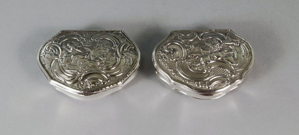 A George II silver snuff box, London c.1743, maker's: A George II silver snuff box, London c.1743, maker's mark RC, the cover chased with a rococo landscape, approx 7cm x 5cm, together with a similar snuff box, London c.1752 by the same maker, the cover 