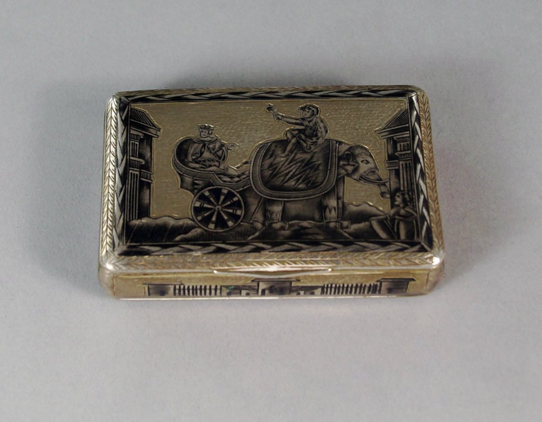 A Russian silver niello snuff box, Moscow 1827, assay: A Russian silver niello snuff box, Moscow 1827, assay master Nikolay Dubrovin, the cover with a scene of king seated in a chariot being drawn by an elephant, the sides and base decorated with kremlins