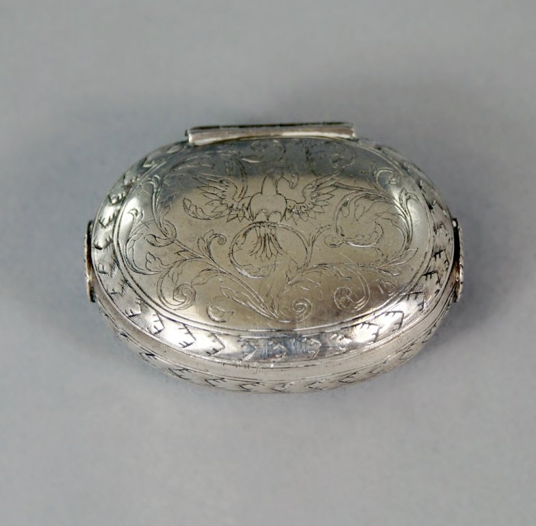 A late 17th century silver snuff or spice box, maker's: A late 17th century silver snuff or spice box, maker's mark AD conjoined struck once inside the body, of oval form with squeeze action opening via a floral lozenge applied to either side, the cover en
