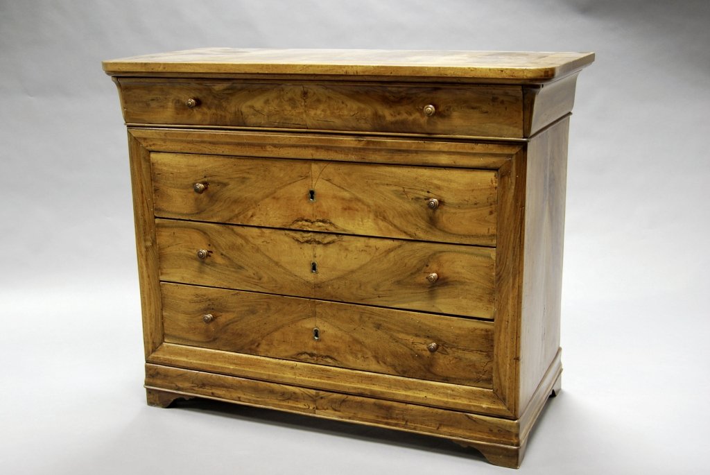 A French walnut commode, 19th century, with a moulded: A French walnut commode, 19th century, with a moulded top edge, above a frieze drawer and three book-matched veneered drawers, raised on bracket feet, 91 cm high x 111 cm wide x 54 cm deep.