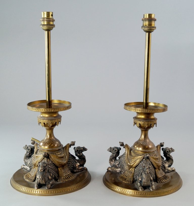 A pair of bronze and silvered bronze tazza bases, 19th: A pair of bronze and silvered bronze tazza bases, 19th century, possibly after a design by Elkington, converted to lamp bases, modelled as three camels seated and draped with oriental rugs, the bases 