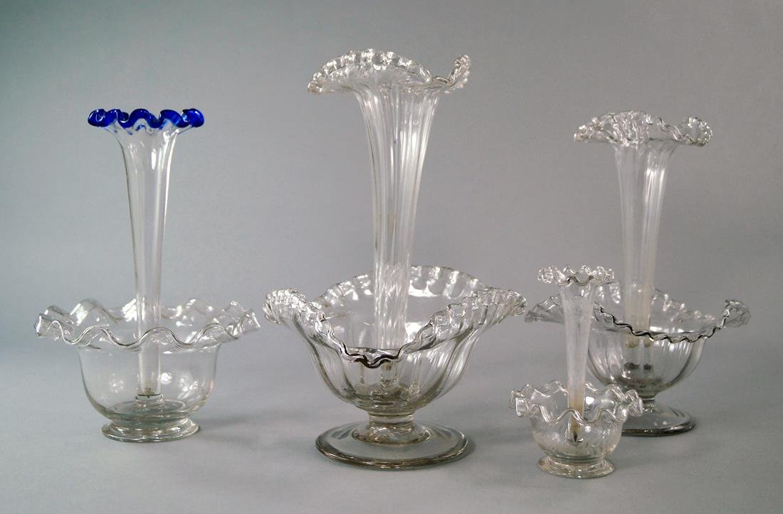Four Victorian glass epergnes, two with single central: Four Victorian glass epergnes, two with single central trumpet vases, with crimped trefoil tops, on conforming bases, with spreading feet, and two of circular form, the tallest 28cm high (4)