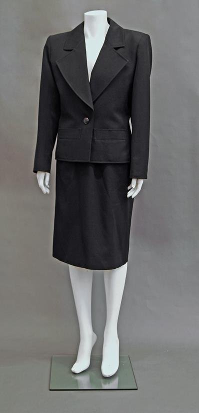 Yves Saint Laurent: A black jacket and skirt suit,: Yves Saint Laurent: A black jacket and skirt suit, 1980s, the cropped jacket with wide lapels and single button fastening, together with an Yves Saint Laurent haute couture olive green safari jacket, 