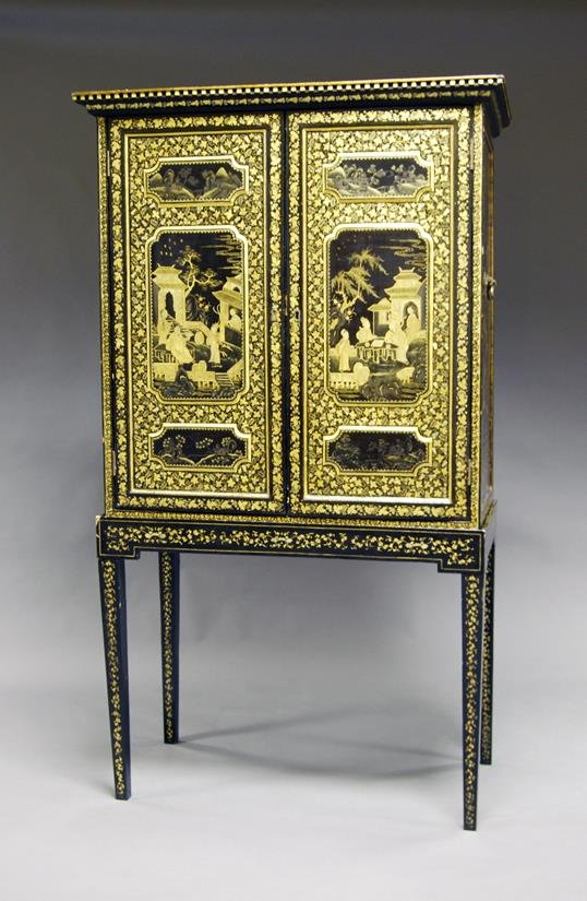 An Early 19th Century and later Chinese export black: An Early 19th Century and later Chinese export black lacquered cabinet on stand, having moulded dentil cornice over two doors which open to reveal two short over three long and two further short drawe