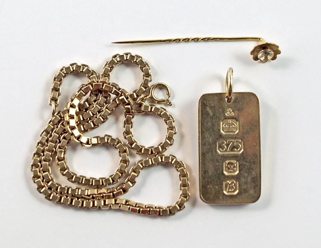 A 9ct gold ingot, 1976, together with a 9ct gold box: A 9ct gold ingot, 1976, together with a 9ct gold box link chain, approx 46cm and a 9ct gold stick pin, of flower head form, set with a clear stone, approx 42.6g. (3)