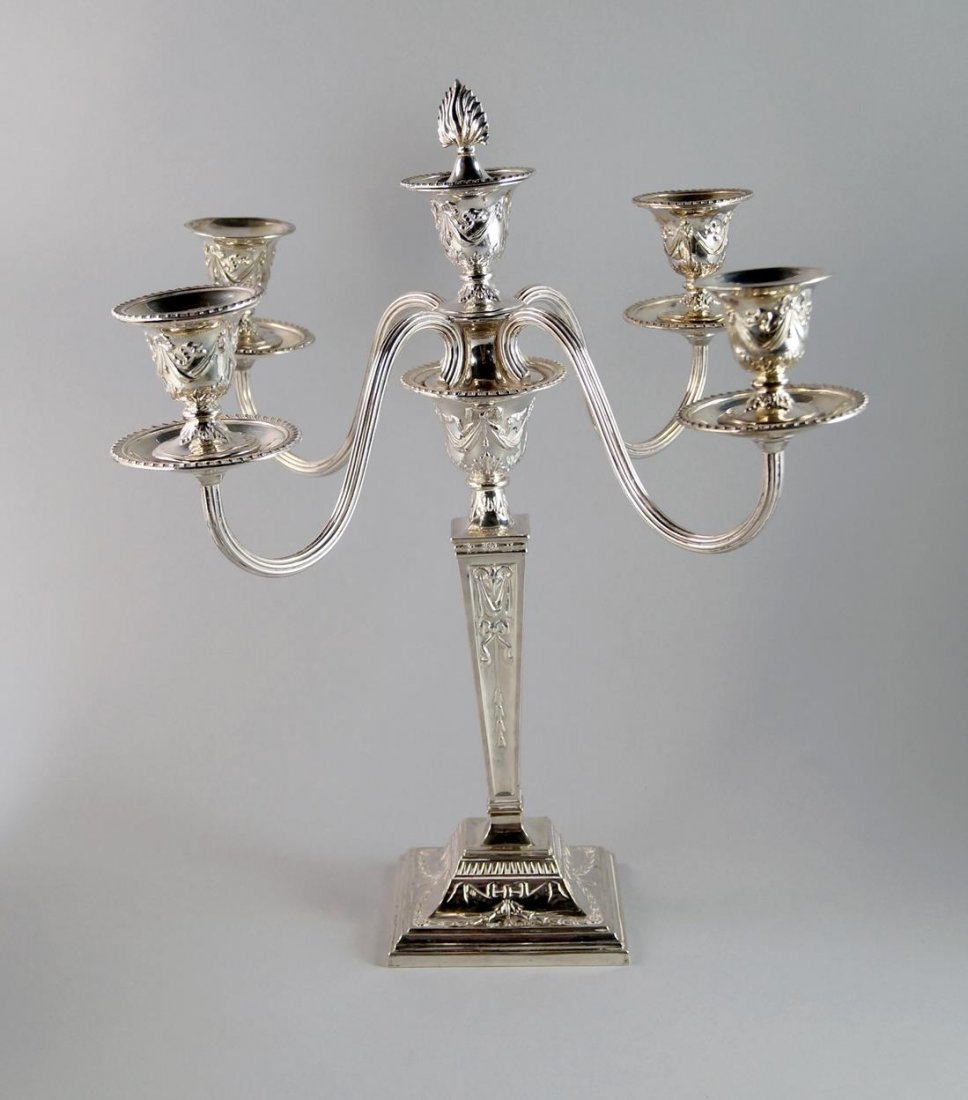 A silver four branch candelabra, London c.1964, A. Tait: A silver four branch candelabra, London c.1964, A. Tait & Sons Ltd, of neo-classical form, the sconces with ribbon and swag embossing, four reeded scroll arms to a tapering column with embossed rams h