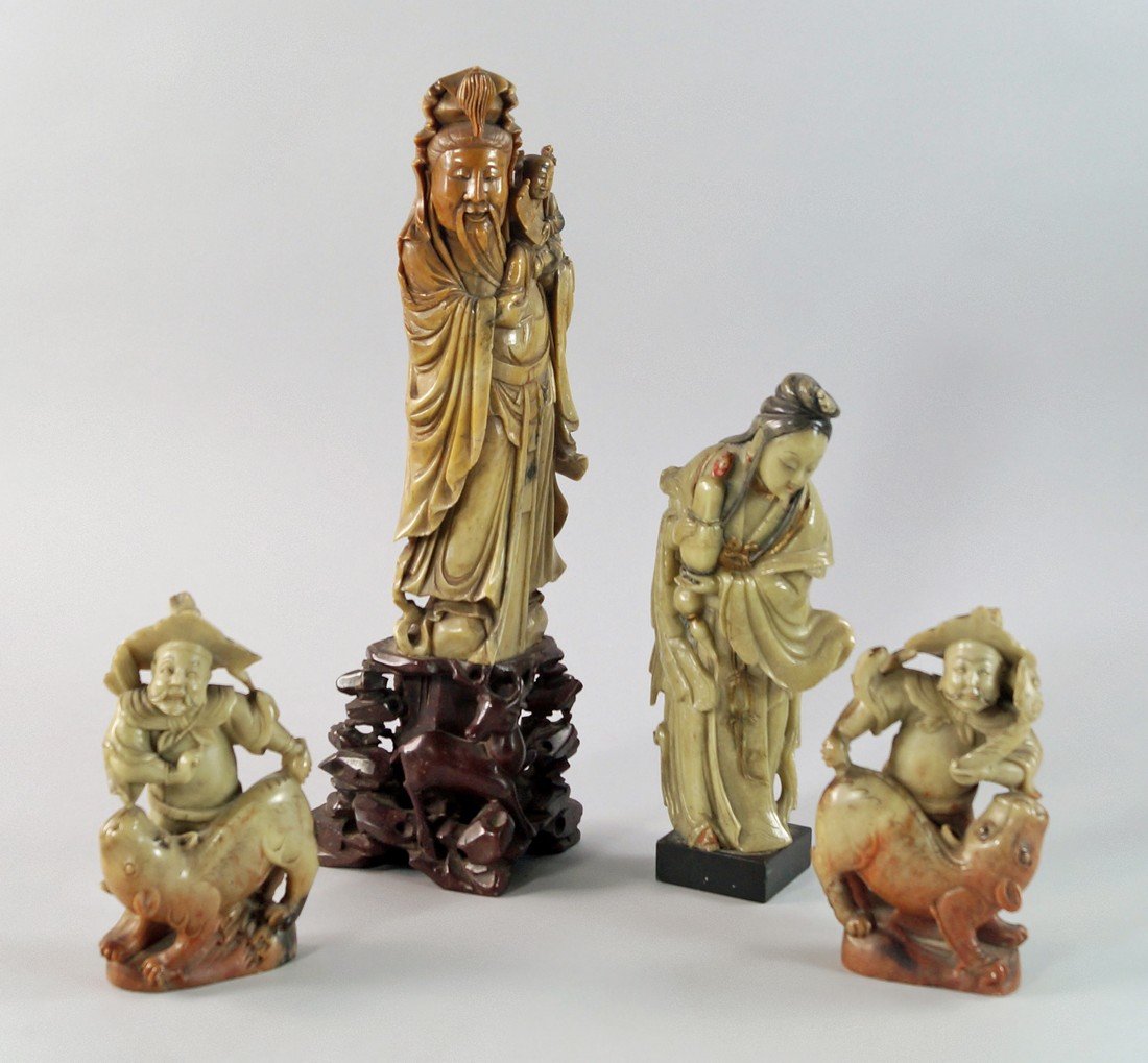 A pair of Chinese soapstone figures of men, late: A pair of Chinese soapstone figures of men, late 19th/early 20th century, modelled wearing wide hats with beards and moustaches, both wrestling mythical lions, 14cm high, together with a green soapsto