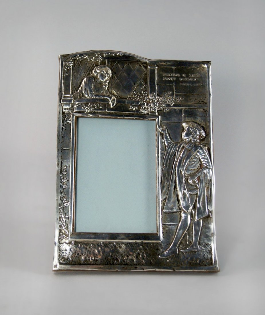 An Arts & Crafts silver mounted easel photograph frame,: An Arts & Crafts silver mounted easel photograph frame, Birmingham 1906, Walker & Hall, embossed image of Romeo and Juliet, with verse 'Parting Is Such Sweet Sorrow' approx 25cm x 18cm.