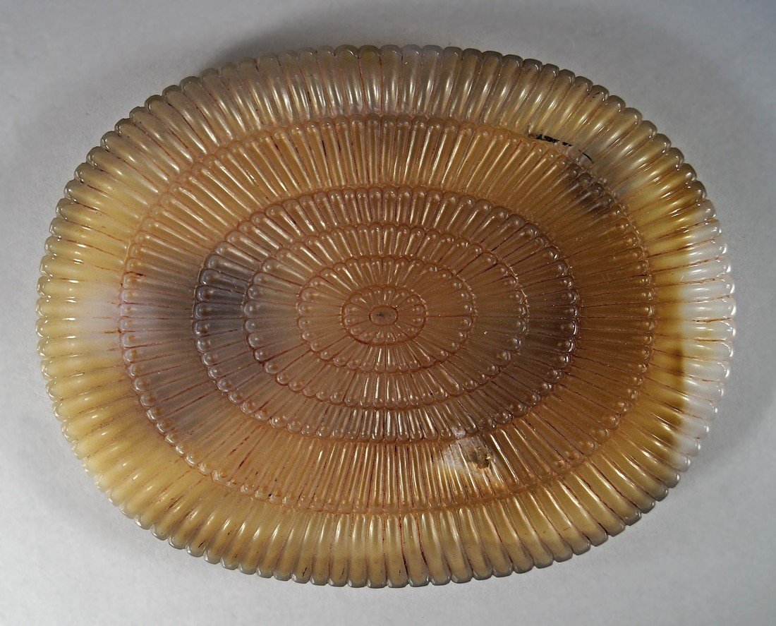 A mutton fat jade style oval dish in the Mughal taste,: A mutton fat jade style oval dish in the Mughal taste, the edge with semi circular ridged rim, with lobed exterior and stylised petal form flower to the base, carved to the interior centre with a flow