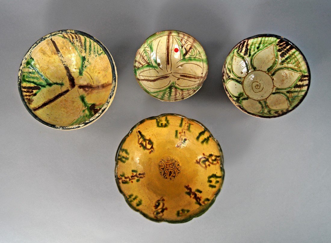 A Nishapur sgraffito splashware pottery bowl, 10th: A Nishapur sgraffito splashware pottery bowl, 10th Century, the earthenware body incised with petal and heart motifs radiating from the centre, decorated with splashes of green, brown and aubergine gl