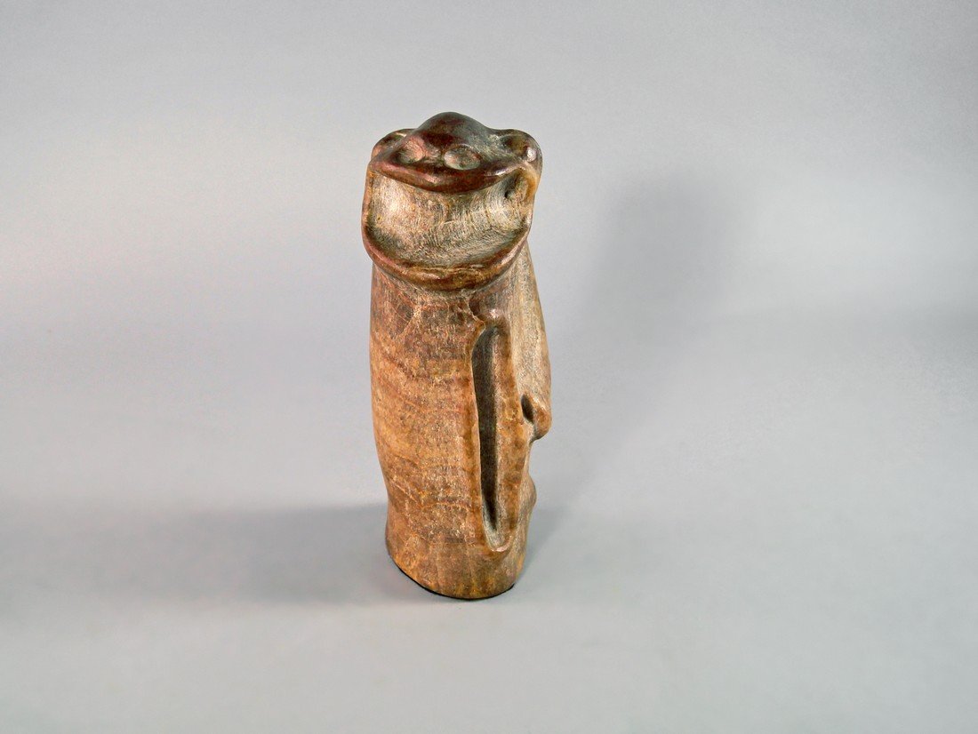 A carved and polished pink hard stone model of a Zemi: A carved and polished pink hard stone model of a Zemi or Semi, in the Taino Pre Columbian style, having typically wide mouth and bulbous eyes, the body of carved column form, 21.5cm high Provenance: T