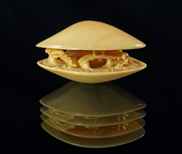 A Japanese ivory model of a shell, late 19th/20th: A Japanese ivory model of a shell, late 19th/20th century, sometimes referred to as the 'Clams dream', carved open with a landscape within, 4.5cm wide