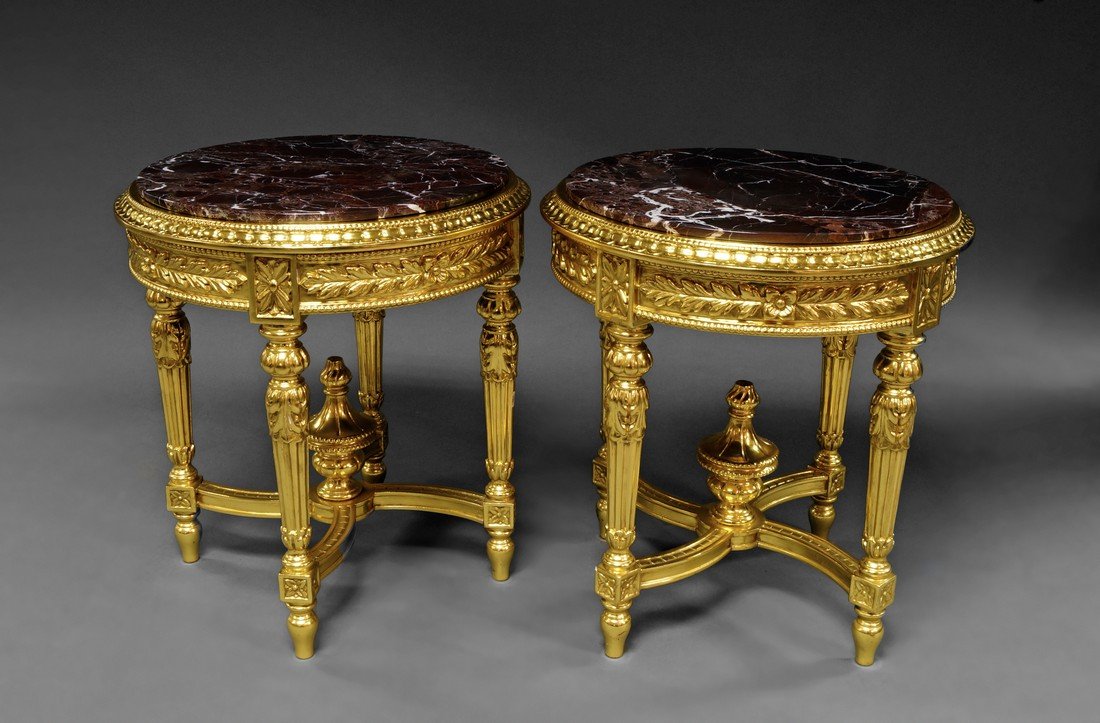 A pair of Italian marble and giltwood circular side: A pair of Italian marble and giltwood circular side tables, the rouge marble top above foliate carved apron, on flared fluted legs, joined by stretchers, makers marks for ''Meritalia'', 67cm high x 60