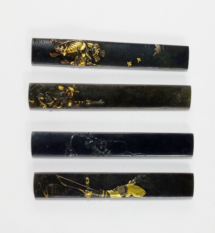Four shakudo knife handles, kozuka, Edo Period, three: Four shakudo knife handles, kozuka, Edo Period, three applied with figures of warriors, one with a monk, 7.5cm long (4) (VAT charged on hammer price)