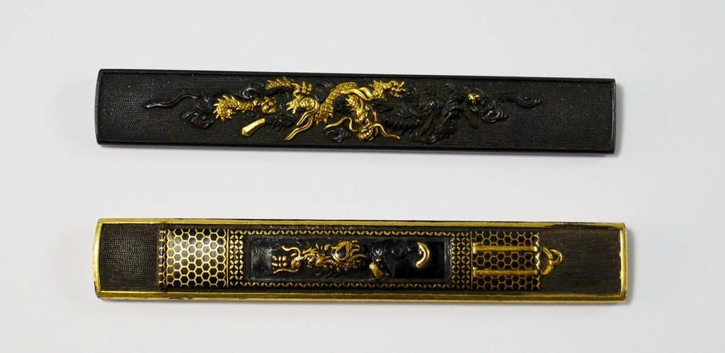 Two shakudo knife handles, kozuka, Goto School Edo: Two shakudo knife handles, kozuka, Goto School Edo Period, one applied with dragons and one with a scroll painting of a dragon, 10cm long (2) (VAT charged on hammer price)