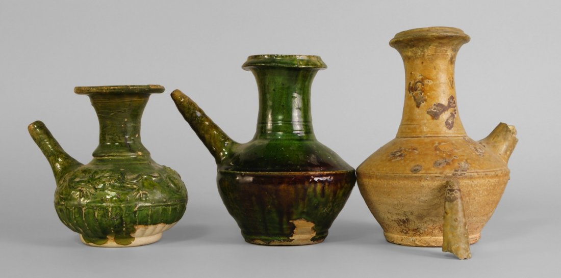 A Chinese sancai glazed kendi, 14th/15th century, and: A Chinese sancai glazed kendi, 14th/15th century, and two similar kendis, one decorated in relief to the shoulders with dragons, 12cm-17cm Cf. Oriental Trade Ceramics in South-East Asia, John S. Guy, 