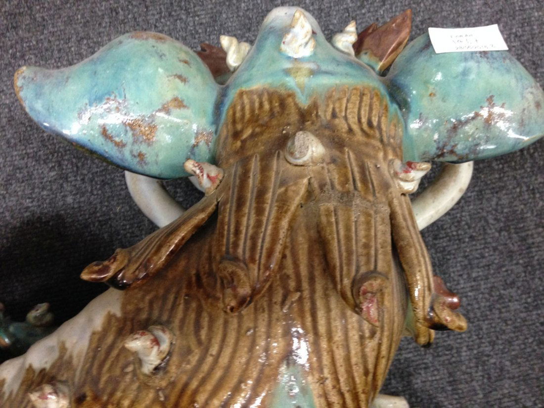 A pair of large Chinese stoneware Dog of Fo roof tiles,: A pair of large Chinese stoneware Dog of Fo roof tiles, 18th/19th century, one modelled with a puppy under her paw, the other with a ball, glazed in turquoise, buff and red, 35cm high, 50cm long (2)