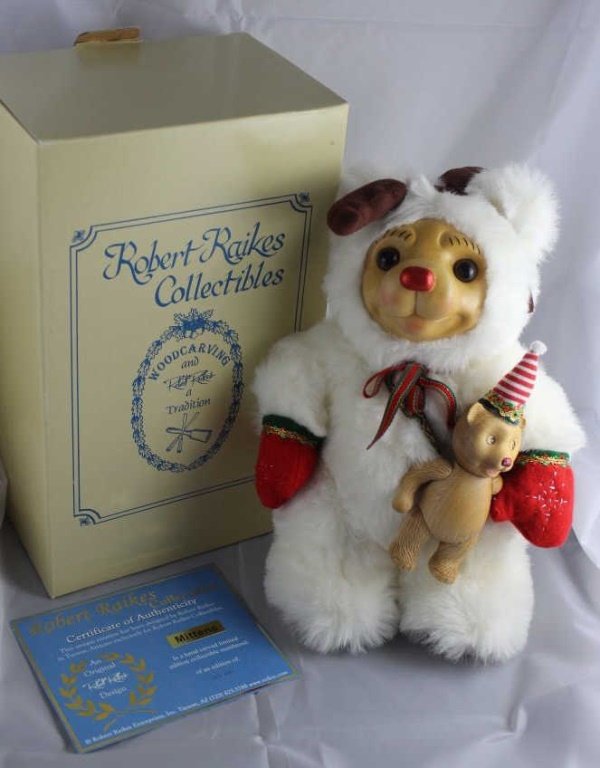 Raikes Mittens (Christmas)-672.: Raikes Mittens (Christmas)-672. Dressed with brown fabric antlers on head and bright red mittens. She wears a wooden doll (Woodikin) attached to a holiday ribbon on her chest. Ltd. #151 of 400.