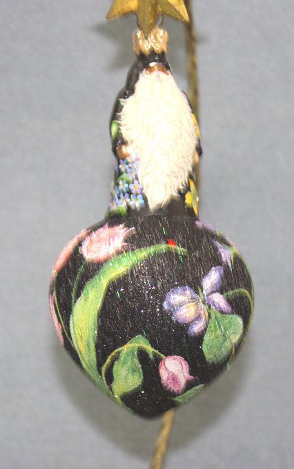 Patricia Breen "Spearman Santa" Ornament: Patricia Breen "Spearman Santa-Black Floral" Christmas ornament. A black matte-robed Santa standing on a black glittered bulb. All surfaces are decorated with pastel multi-colored flowers except for S
