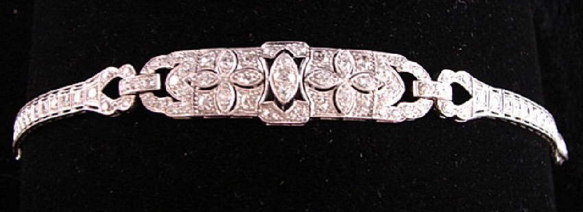 Lady's Platinum Art Deco Diamond Bracelet: One old European cut center diamond wt approximate .15 ct and a pair of single cut diamonds wt approximately .05 set horizontally flanking center stone, surrounded by thin 8 carnelian en-cabochon cuts