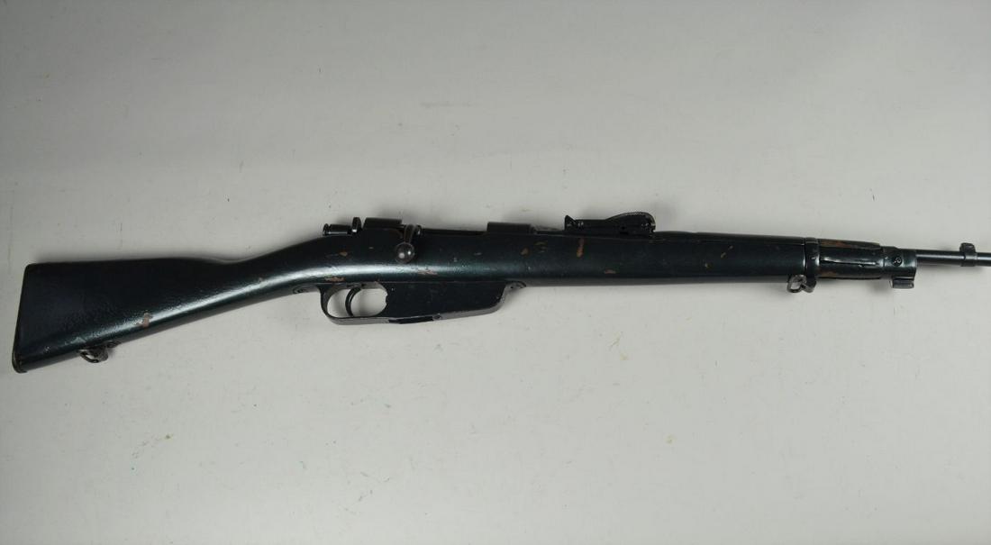 Model 1891/24 Carcano Carbine*: in 6.5 x 52. Entire gun has been painted green with metallic car paint. Bore is very good with moderate pitting. Stock shows multiple scratches. Sight is loose. Barrel 18", overall 36". *Registration 