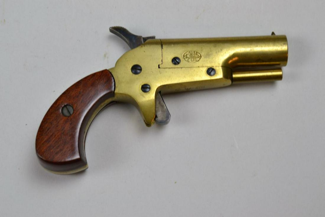 CVA Percussion Derringer: in .31 caliber. All brass frame and smooth bore barrel. Shows light wear, approximately 90% case colors. Grips very good with minor bruising. Barrel 2 1/2", overall 5"