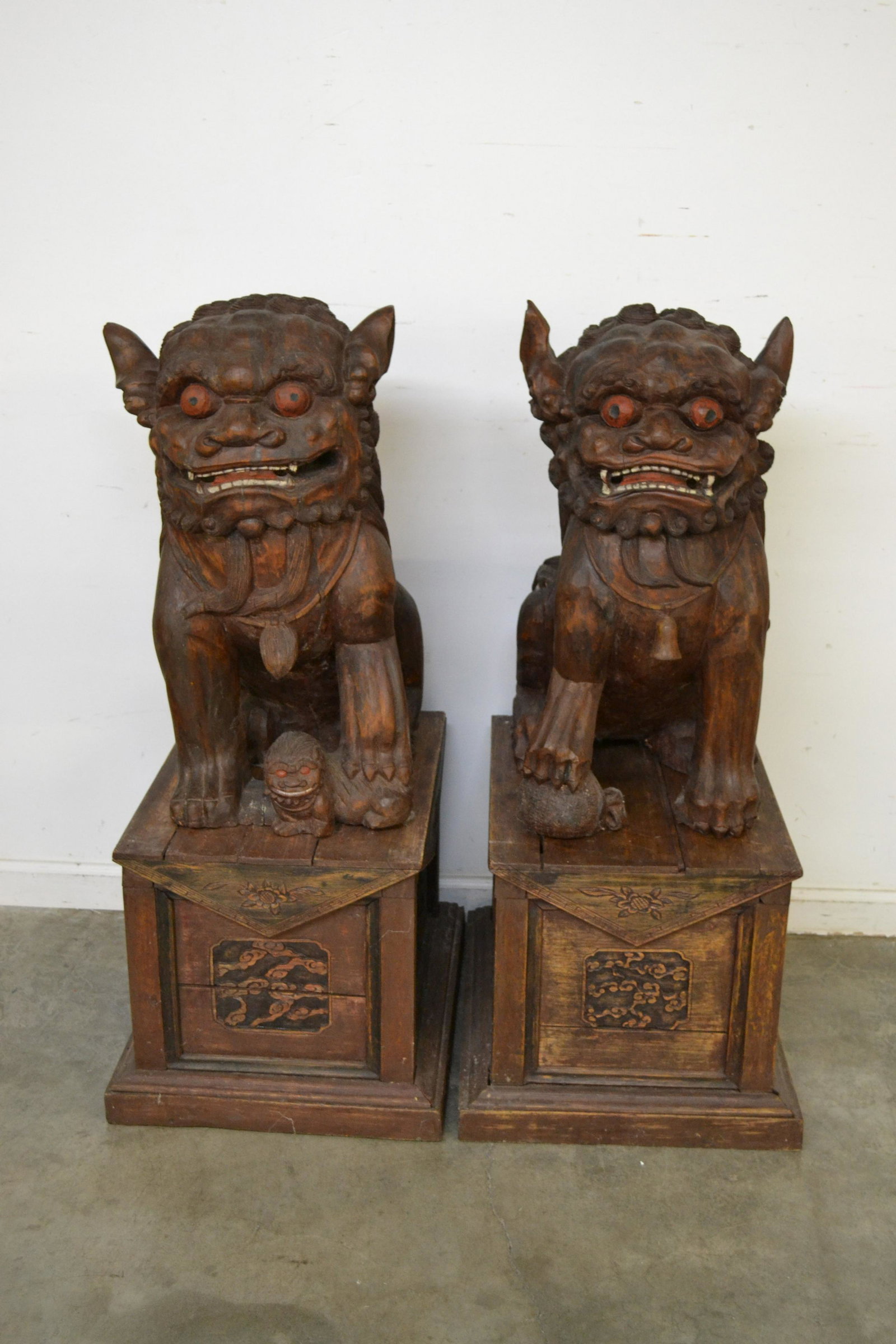 Exceptional Pair of Chinese Foo Dogs: male and female, highly carved in the Ming Dynasty style with rare degree of detail. Accompanied by two pedestals with carved panels. Pedestals are loose and missing pieces. Dogs measure: 26" h x 15" 