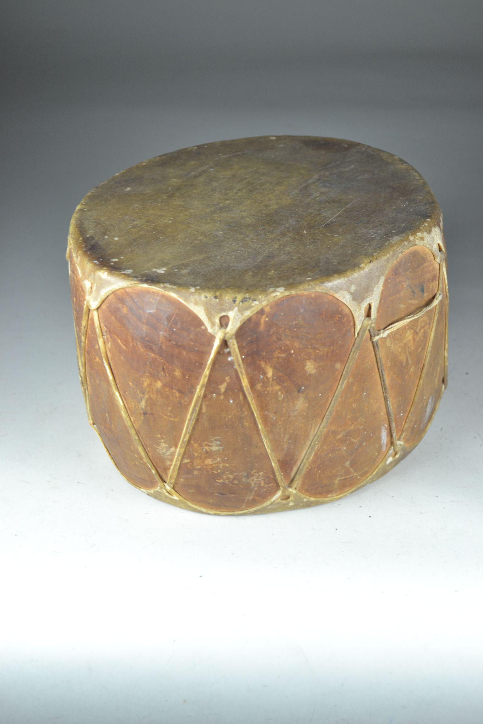 Vintage Small Rawhide Covered Wooden Drum: spots of insect damage in wood and a few spots in the rawhide itself. Moderate wear from use. 6" h x 9" w
